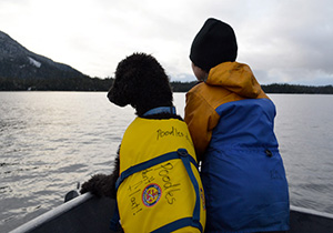 Dog and boy on boat in Southeast Alaska