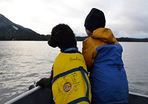 Dog and boy on boat in Southeast Alaska Dog and boy on boat in Southeast Alaska